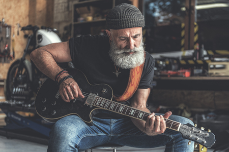 Concentrated elder man holding instrumentの写真素材