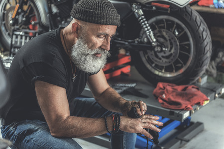Thoughtful old man using small rag after work