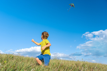 Carefree kid playing with flying toy on grass fieldの写真素材