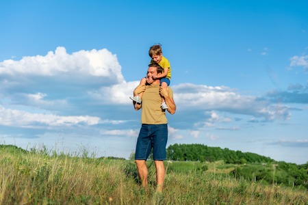 Cheerful family spending playtime on meadowの写真素材