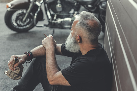 Relaxed aged male person keeping cigar