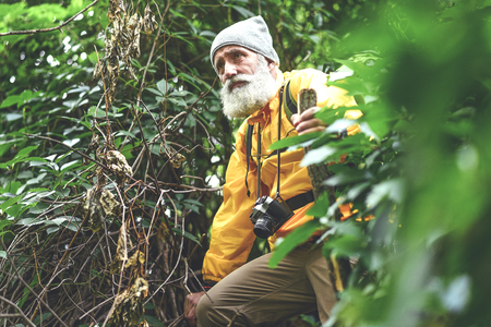 Thoughtful senior male hiker walking in wild natureの写真素材