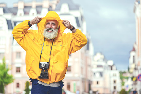 Cheerful senior male tourist walking in townの写真素材