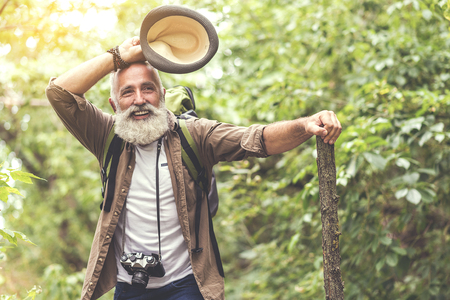 Happy senior male tourist hiking in forestの写真素材