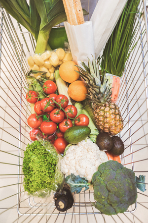 Full shopping grocery cart situating in shopの写真素材