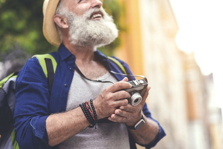 Excited old male tourist taking photos in townの写真素材