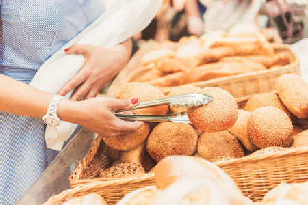 Adult consumer taking small bread