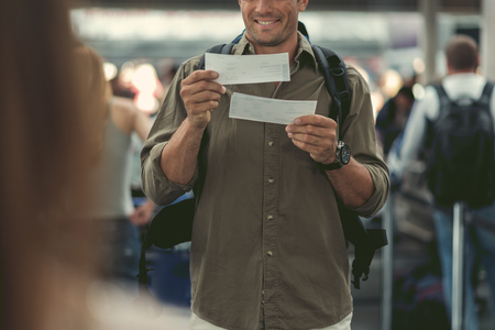 Positive young guy is waiting for flightの写真素材