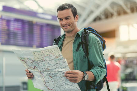 Cheerful adult man is waiting for departureの写真素材