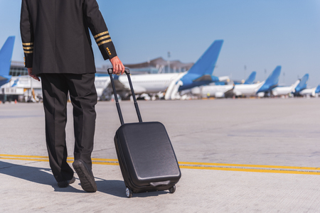 Mindful smiling airman near luggageの写真素材