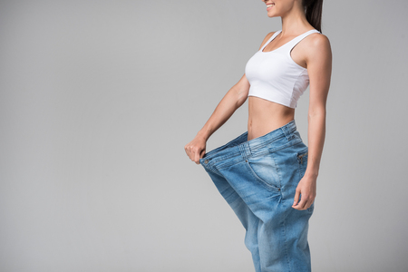 Joyful girl showing her thin figure after dietingの写真素材