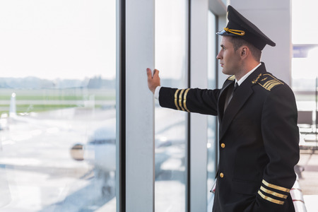 Serious aviator looking at window
