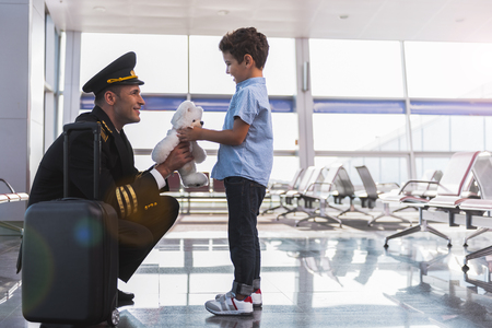 Happy smiling aviator presenting toy his childの写真素材