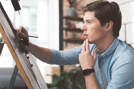 Serious youthful engineer is laboring on blueprintの写真素材