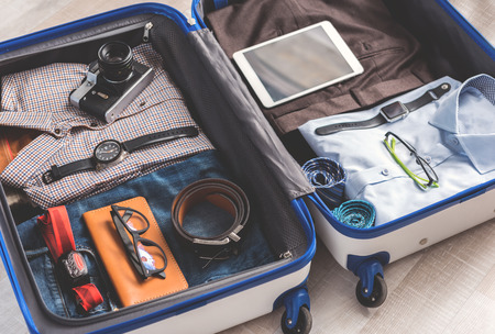 Work and vacation. Different accessories are locating on things to wear at parts of luggage. Top view close up. Nobodyの写真素材