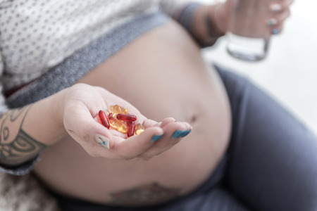 Expectant woman going to take medicineの写真素材