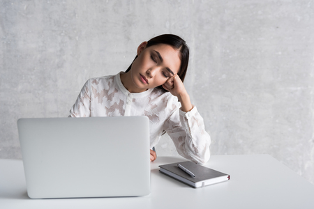 Tired lady sleeping at workplaceの写真素材