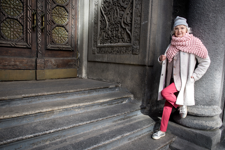 Self-sufficient mature lady standing near architectural gateの写真素材