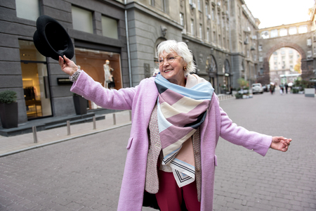 Romantic senior lady enjoying walk in townの写真素材