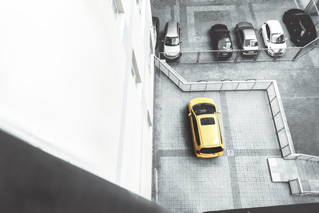 Yellow element. Top view of bright car is on parking among black and white autos. Copy space in the left sideの写真素材
