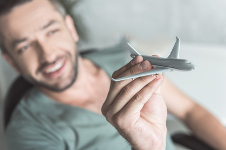 Joyful guy is holding little aircraftの写真素材