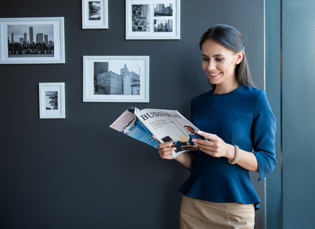 Pleasant elegant girl is enjoying journalの写真素材