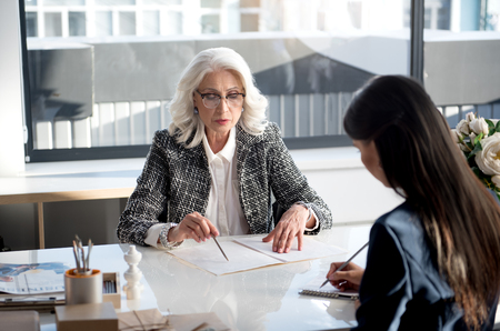 Confident charming women are laboring together in officeの写真素材