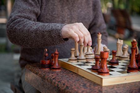Arm of old man playing chess in parkの写真素材