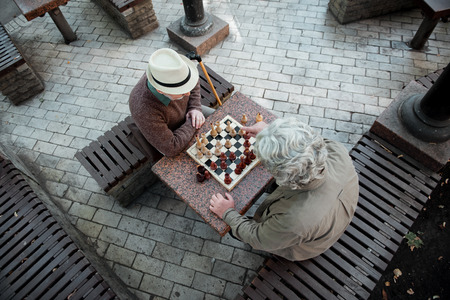 Pensive mature men entertaining with chessboardの写真素材