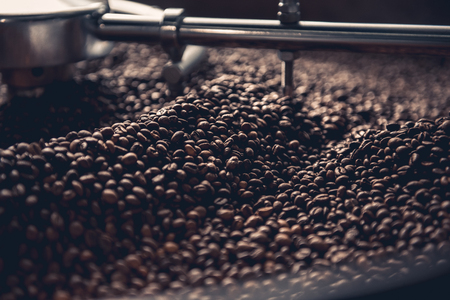 Close up aromatic coffee beans situating in professional machine with grain chiller. Prepare conceptの写真素材