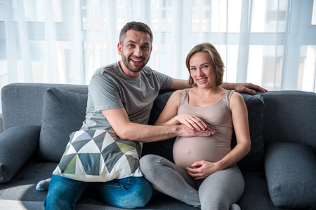 Forthcoming happiness. Portrait of joyful married couple are glad about female pregnancy. They are...