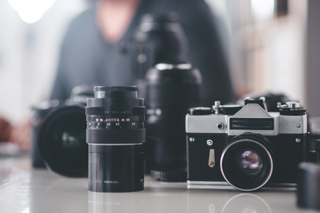 Close up different cameras with optical objective situating on desk. Photo conceptの写真素材