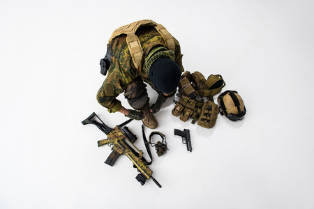 Top view defender tying shoelaces on footwear while preparing army uniform. Arrangement conceptの写真素材