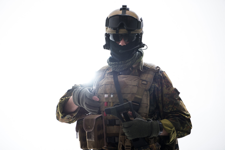 Portrait of serene defender holding assault rifle while looking at camera. Army concept. Isolated