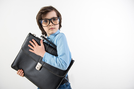 Only mine. Waist up portrait of little future manager holding his document case with frightened face. Copy space in right side. Isolated on backgroundの写真素材