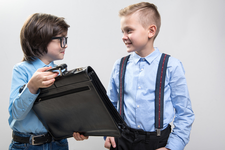 Waist up of two smart children in formal clothing playing in business. Isolated on backgroundの写真素材