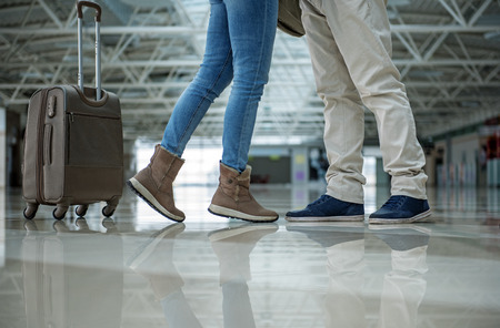 Male and female legs standing close to each other. Luggage is near them. Close upの写真素材