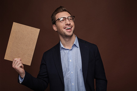 Portrait of beaming man keeping tablet in arm. Profession concept. Isolatedの写真素材