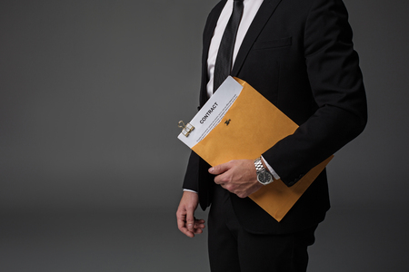 Close up businessman arm keeping contract in folder. Career concept. Isolated and copy spaceの写真素材