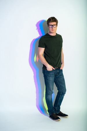 Full length portrait of serene man standing and looking at camera. Seriousness concept