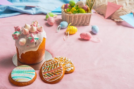 Close up easter cake with cookies locating on red carpet opposite colored eggs. Festive decor conceptの写真素材