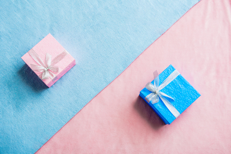 Top view blue and pink beautiful gifts locating opposite each other on fabric. Festive conceptの写真素材