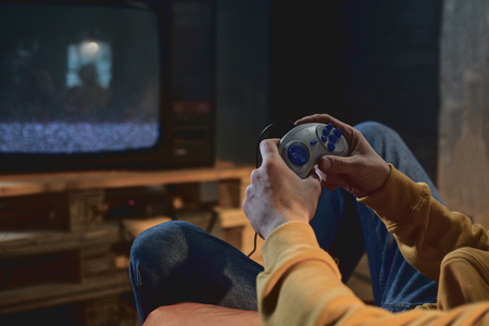 Close up man arm playing in video game in apartment. Relax conceptの写真素材