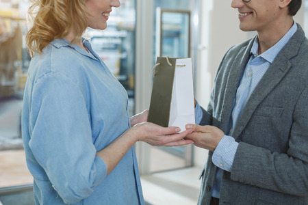 Outgoing wife and cheerful husband holding purchase in arms. Eye care conceptの写真素材
