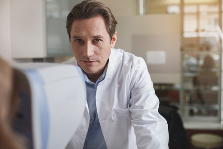 Portrait of concentrated doctor working with electronic equipment in modern office. Physician during labor conceptの写真素材