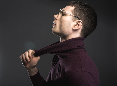 Side view male in modern glasses expressing seriousness while pulling collar. Gravity conceptの写真素材