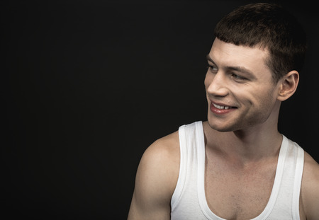 Portrait of glad young man isolated on black background. Copy space. Happiness conceptの写真素材