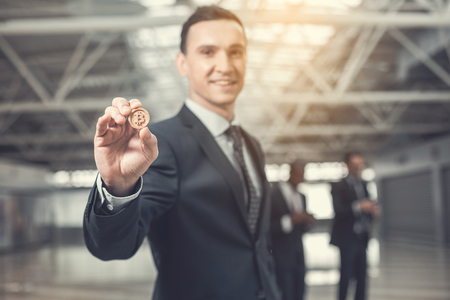 Portrait of smiling young employer showing money while keeping it in arm. Emolument from labor conceptの写真素材