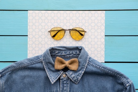 Top view close up of modern shirt, spectacles and casual bowtie situating on paper. Style conceptの写真素材