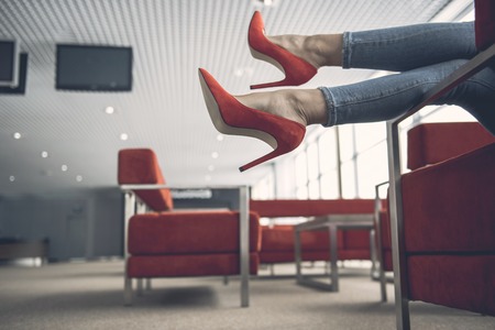 Close up female legs lying on cozy sofa in room for relaxingの写真素材